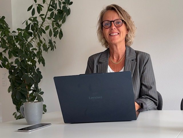 Pernille Nielsen ved sit skrivebord med den bærbare computer åben